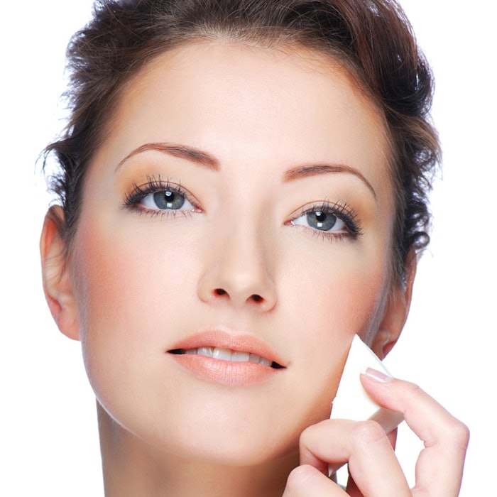 Close-up face of beauty young woman applying face foundation