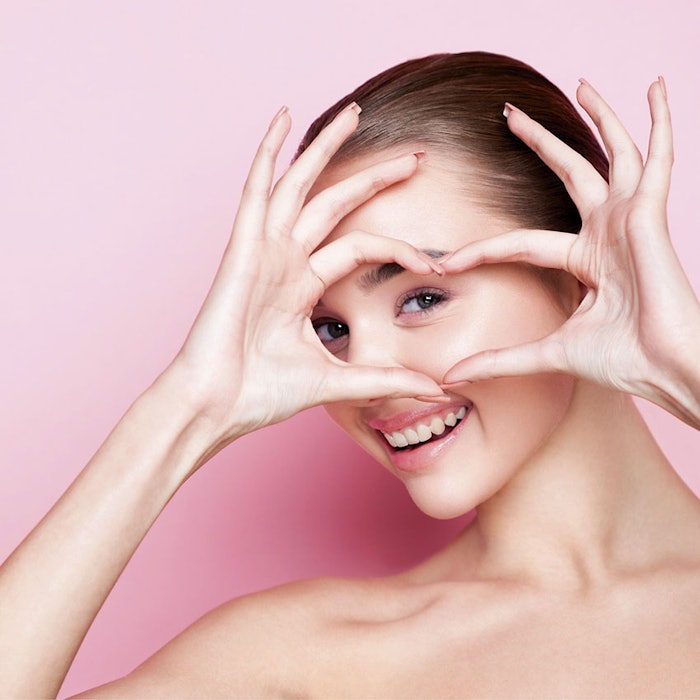 WomanonPinkMakingHeartwithHands850