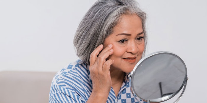 MatureAsianWomanLookingatWrinklesinMirror_850x425