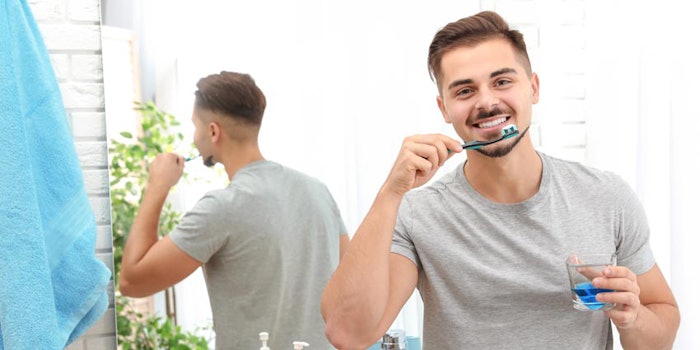 ManUsingOralCareProductsToothpasteMouthwashinBathroomMirror_850x425