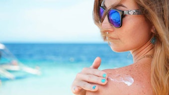 WomanTurquoiseSeaApplyingSunscreentoShoulderPaintedNails_850x425