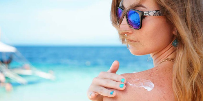 WomanTurquoiseSeaApplyingSunscreentoShoulderPaintedNails_850x425