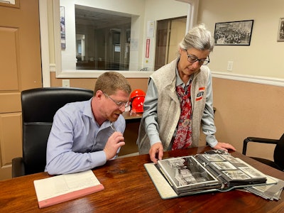L to R: Sales manager, Arthur Kapp alongside president, Jocelyn Manship reviewing photos from the company's past.