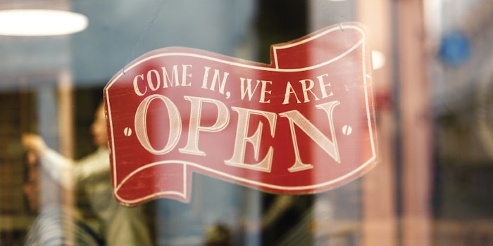 An open sign that reads 'Come in, we are open' hangs on a window front.