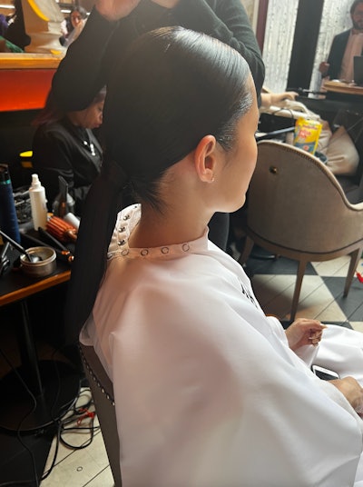 The hair look for Maison Atia’s A/W ‘23 preview was a high shine polished ponytail with a center part.