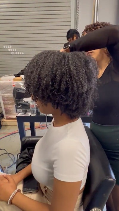 Brenda Espinosa styles her model's curly hair at World of Texture.