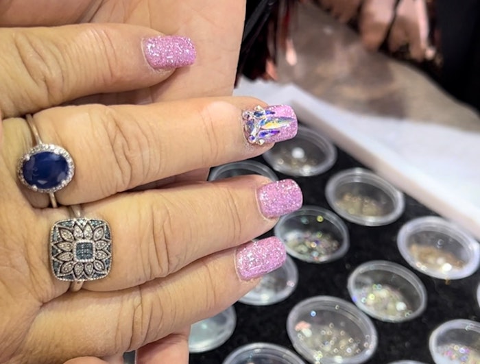 Tino Vo bedazzles nails at the Dreamtime Creations booth at America's Beauty Show 2023.