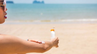 Woman Applying Sunscreen At Beach Adobe Stock 158259786