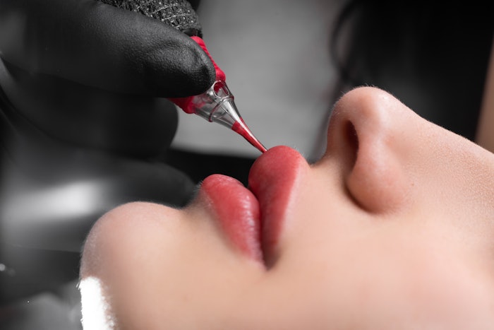 Woman having a lip blushing procedure in the spa