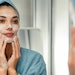 Ct2409 Lionetti Hero Image Woman Cleansing Her Face Looking In Mirror Blue Towel Adobe Stock 535197440
