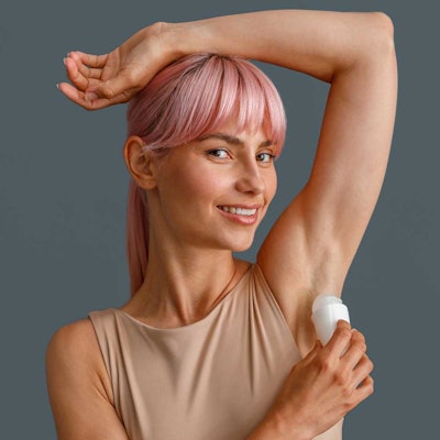 gen-y-woman-pink-hair-applying-deorodant-AdobeStock