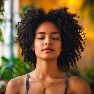 young-Black-woman-meditating-relaxed-eyes-closed-wellness-concept
