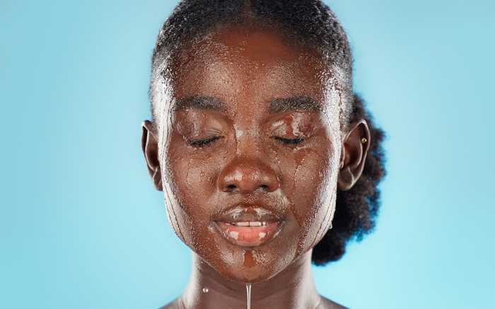 Young woman washing her face