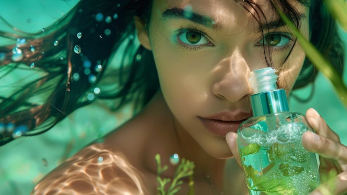 beautiful young woman hair floating under water holding bottle of marine plants
