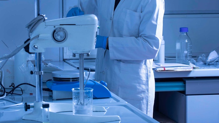 chemist in lab using mixer blue tone