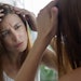 woman in mirror examining scalp stressed long red hair