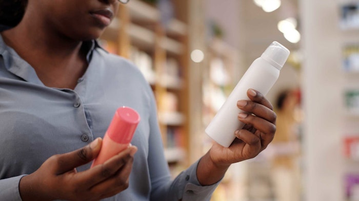 woman in store -consumer-reviewing-personal-care-product-sprays