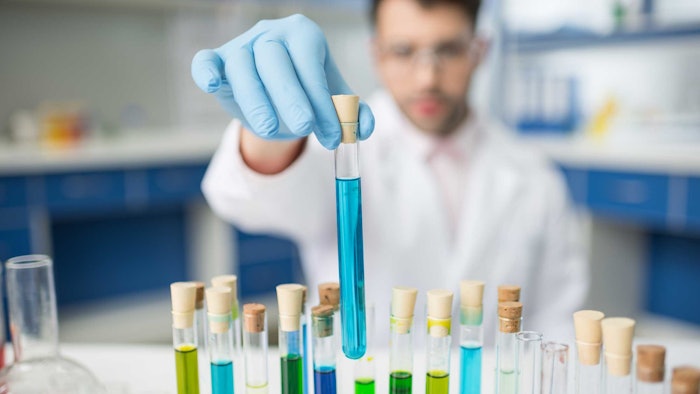 chemist in lab with materials test tubes colors