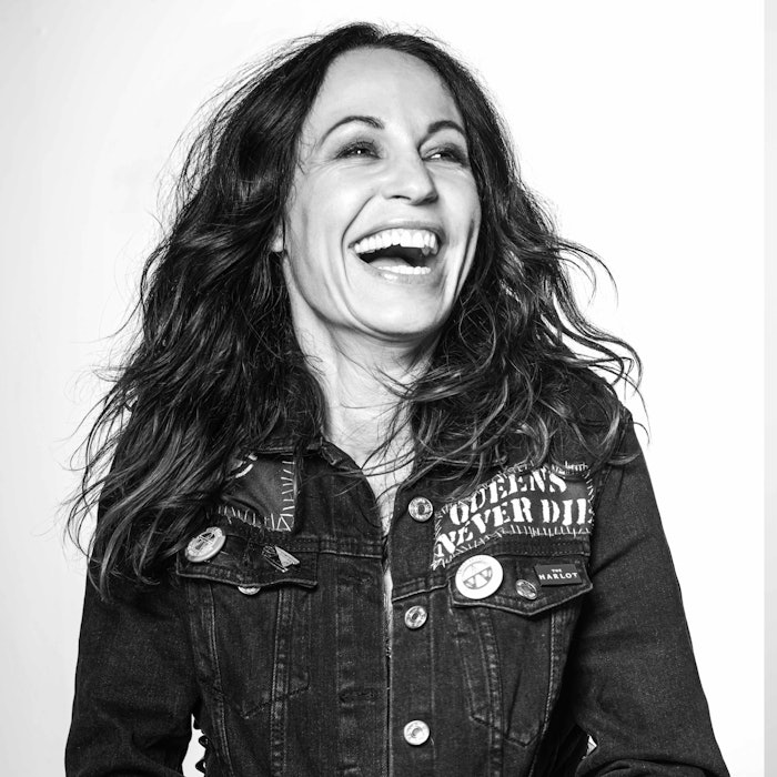 Marylle Koken wearing a jean jacket and smiling as she looks away from the camera.