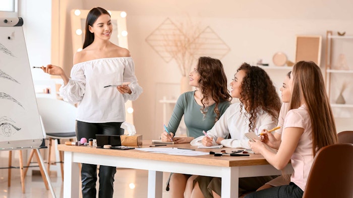 person presenting beauty concepts to table of women