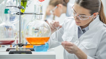 young female chemist in lab preparing samples