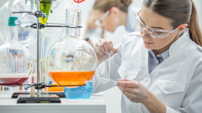 young female chemist in lab preparing samples