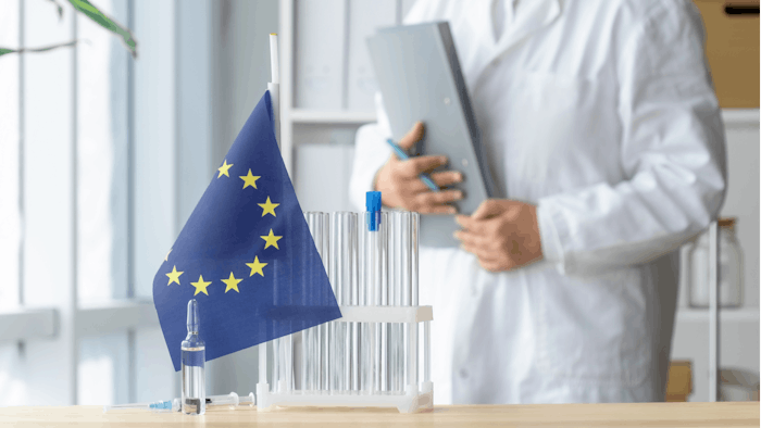 chemist in lab white coat test tubes EU flag