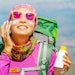 woman hiking mountains backpack using sunscreen