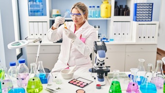 young beautiful chemist testing cosmetic samples in lab