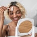 young black woman blonde hair mirror facial massage tool