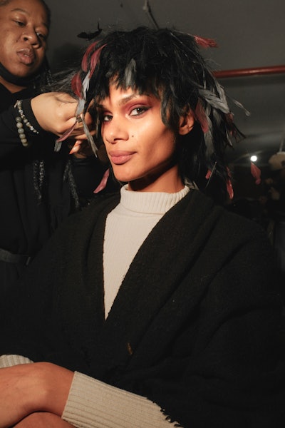 Model sporting a feathered hairstyle at GUVANCH's NYFW show.