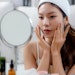 Beautiful Young Asian Woman Using Skin Care Looking In Mirror Adobe Stock 1305890064