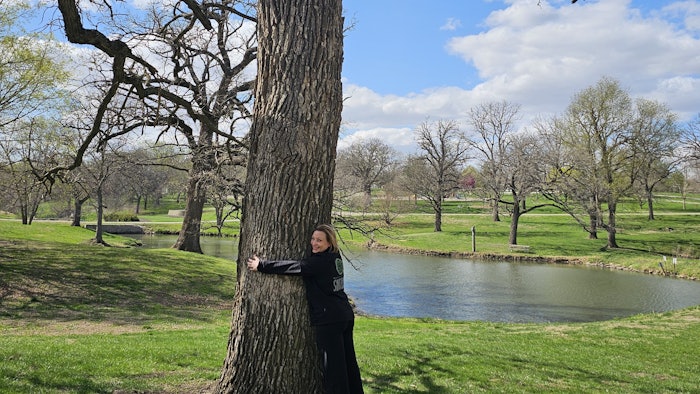 Surface Hair team member hugging a tree.