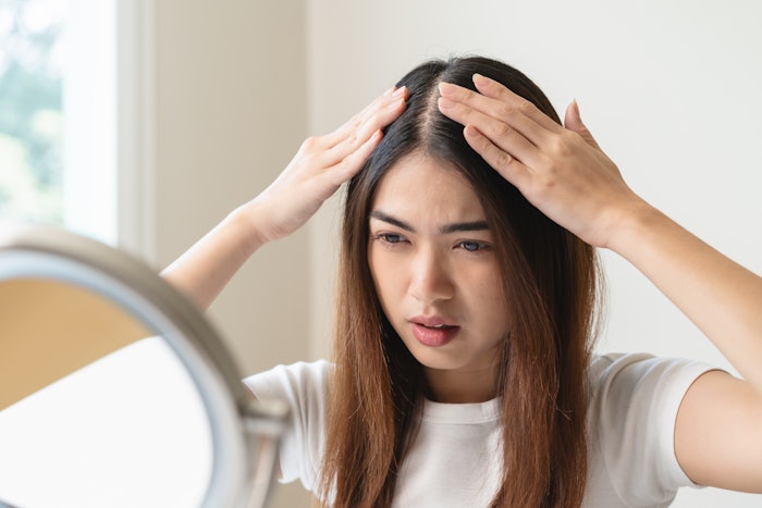 Asian Woman Looking Closely At Hair Part Adobe Stock 811994179