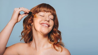 Redhead Applying Facial Serum Happy Emotion Eyes Closed Adobe Stock 540650473