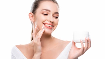 White Background Caucasian Woman Holding White Jar Of Skin Cream Smiling