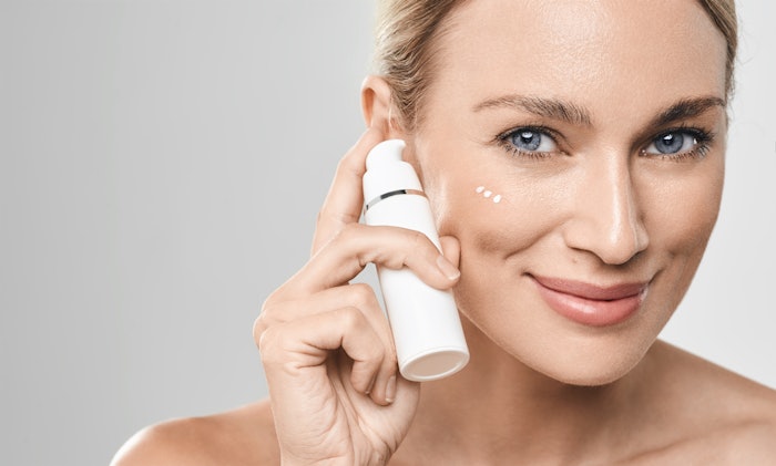 Woman Using Facial Cream Smiling Dabs On Cheek Adobe Stock 514982785