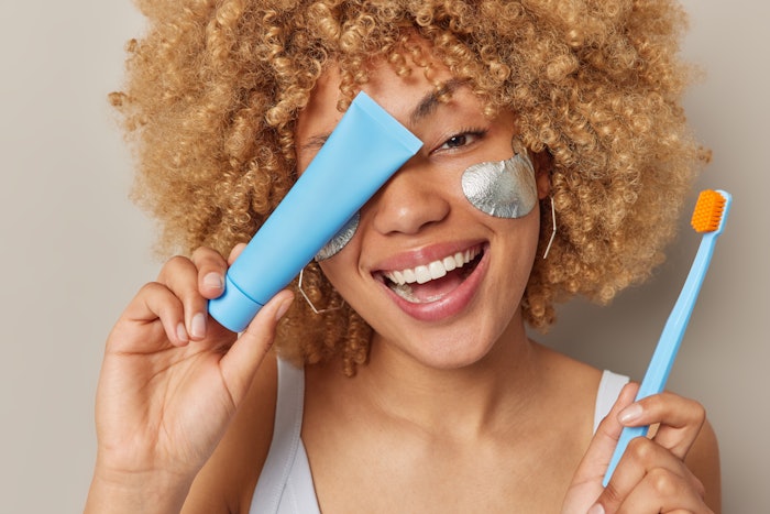 Beautiful Curly Haired Woman Under Eye Patches Oral Care And Tube Adobe Stock 503376344