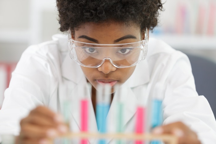Chemist At Bench Examining Samples Adobe Stock 318722948
