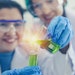 Female Chemists In Lab Holding Beaker Lit Up Adobe Stock 318999036