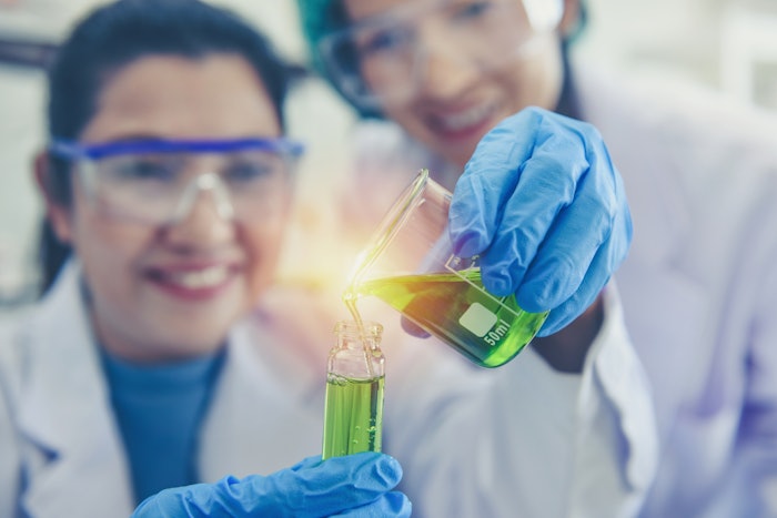 Female Chemists In Lab Holding Beaker Lit Up Adobe Stock 318999036