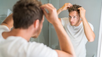 Man Spiking Hair With Hands Looking In Mirror Adobe Stock 167147727
