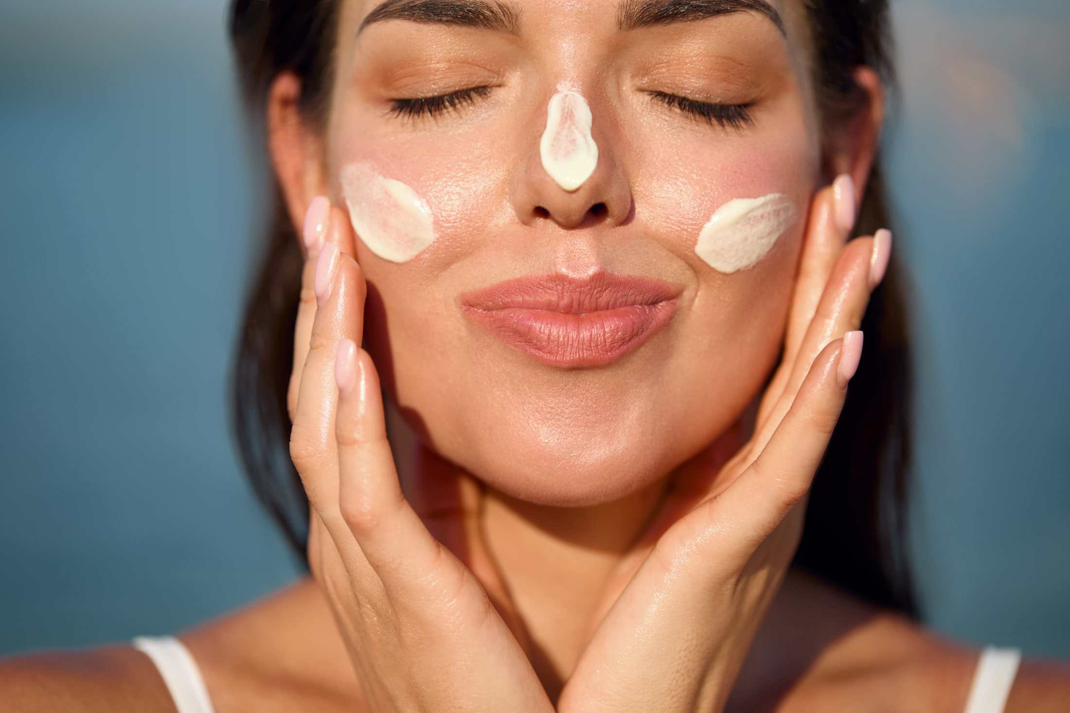 Woman Outside Sunscreen Dabbed On Face Adobe Stock 1325038807