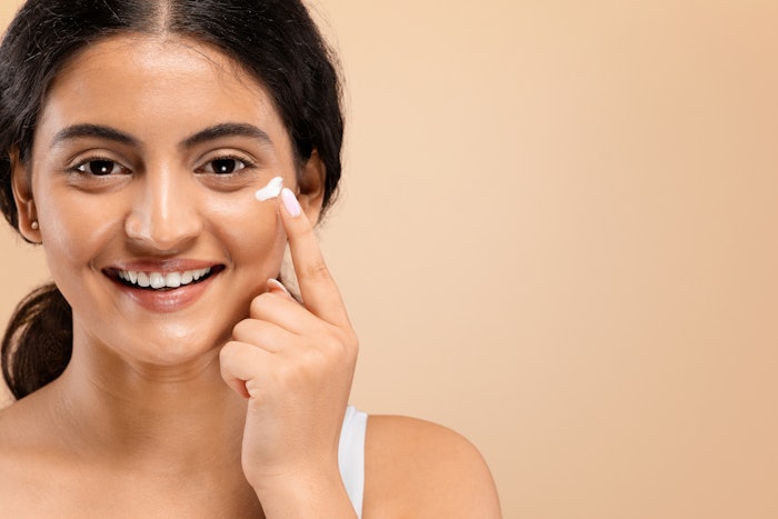 Young Indian Woman Using Eye Cream Smiling Adobe Stock 750183058 (1)