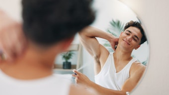 Man With Deodorant In Mirror Adobe Stock 1363485883