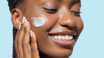 Beautiful Black Woman Using Skin Cream On Face Smiling Relaxed Adobe Stock 1697728328