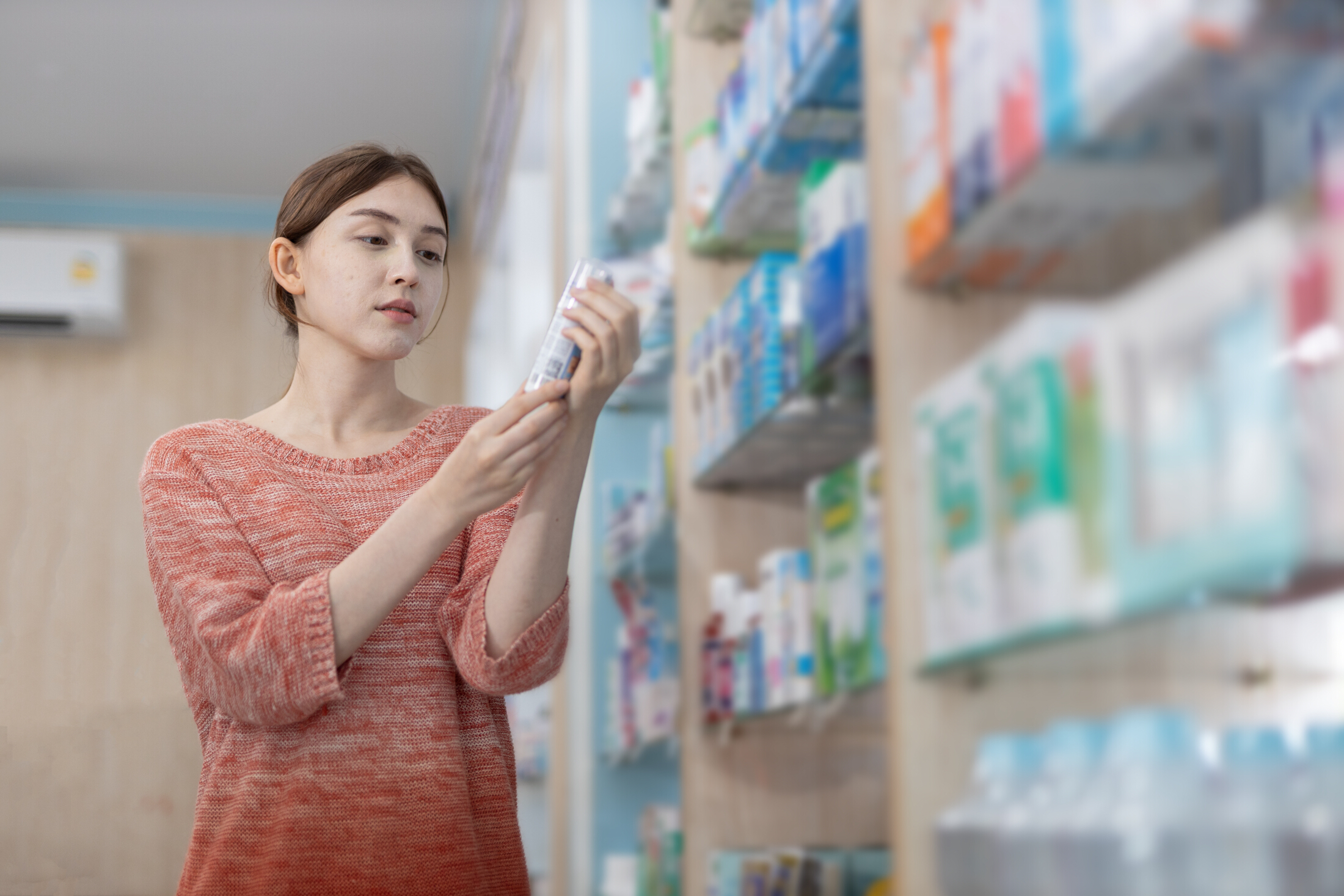 Female Shopper Reading Product Label In Pharmacy Adobe Stock 1764558278