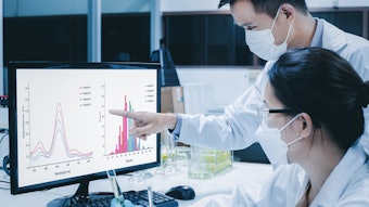 Scientists In Lab Reviewing Data On Screen