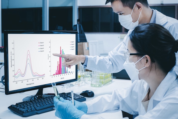 Scientists In Lab Reviewing Data On Screen