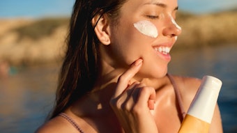 Woman Applying Sunscreen Outside Beach Sunlight Holding Product Adobe Stock 1566888505
